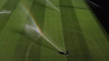 Profesyonel futbol maçından önce futbol sahasını sulamak, bahçe bakımı, futbol maçından önce çim sulama konsepti. 4k yüksek kalitede sinematik HDR görüntüleri 