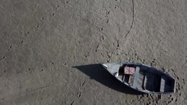 Kurumuş deniz kıyısındaki en iyi tekne manzarası, küresel ısınma ve kuraklık kavramı. Kuru kil üzerinde insan ve hayvan izleri olan rüzgarlı çöl manzarası. 4K yüksek kalite, sınıflandırılmamış insansız hava aracı görüntüleri