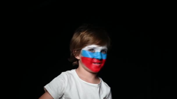 Gelukkige fan viert overwinning van zijn team. Jongeman met gezicht geschilderd in nationale kleuren. Portret van een gelukkig man ondersteunt zijn nationale ploeg thuis — Stockvideo