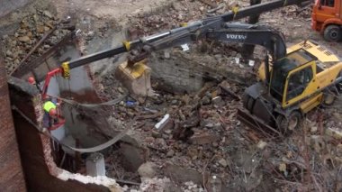 Rostov-on-Don, Rusya - 21 Kasım 2021: Volvo kazıcısı eski bir vintage evi yıktı. Terk edilmiş konutlarda yeni binalar inşa ediliyor. Kentsel Yenilenme 4k Yüksek kalite video