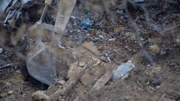 Escavator ássa a fagyott földet hóeséskor. Élő régi ház lebontása a vidéki faluban télen. Városi megújulás 4k kiváló minőségű film videó — Stock videók