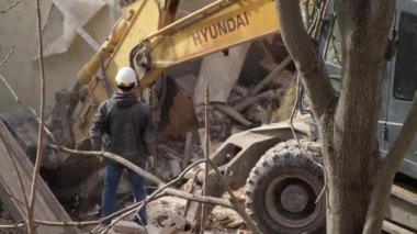 Rostov-on-Don, Rusya - 21 Kasım 2021: Volvo kazıcısı eski bir vintage evi yıktı. Terk edilmiş konutlarda yeni binalar inşa ediliyor. Kentsel Yenilenme 4k Yüksek kalite video