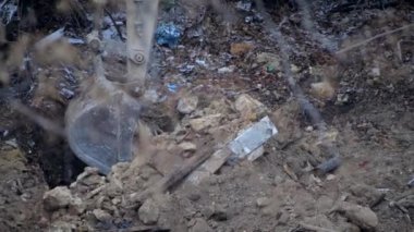 Escavator, kar yağarken donmuş zemini kazıyor. Kışın kır köyünde yaşayan eski bir evin yeniden inşası. Kentsel Yenilenme 4k yüksek kaliteli sinematik video