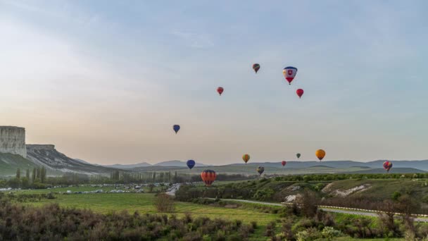 Bela paisagem rochosa da Crimeia com balões coloridos de ar quente voando no pôr do sol, 4k HDR Time Lapse footage — Vídeo de Stock