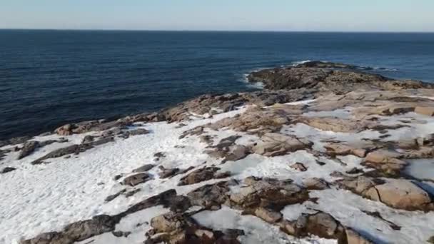 Зимовий повітряний політ зверху над хвилями, що рухаються по морському узбережжю з круглими каменями, океанські хвилі під час шторму, відео безпілотника високої якості взимку — стокове відео