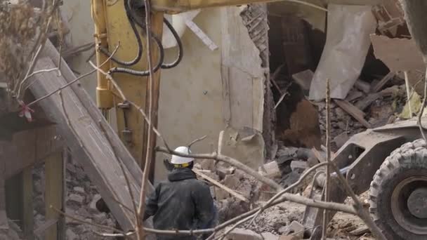 Engineer with protective helmet looks at demolition, destruction of old building, excavator breaks down vintage house. Deconstruction of living object. Urban Renewal 4k High quality slow motion video — Stock Video