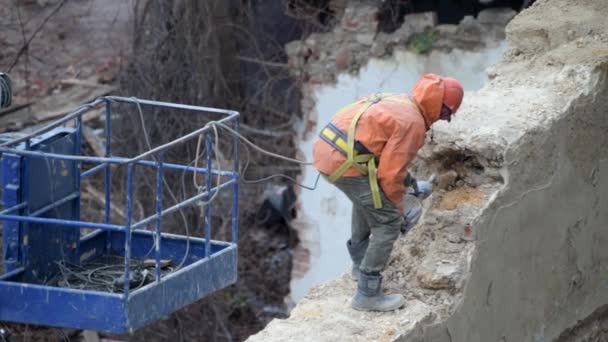 Demolition of old abandoned house, workman in orange helmet destroy wall with jackhammer. Deconstruction of living house. Urban Renewal 4k High quality video — Vídeo de Stock