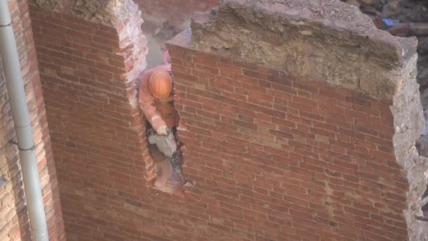 Demolición de la antigua casa abandonada, obrero en casco naranja destruir la pared con martillo neumático. Deconstrucción de la casa viviente. Renovación urbana 4k Video de alta calidad — Vídeos de Stock