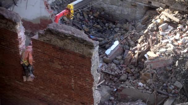 A régi elhagyatott ház lerombolása, a narancssárga sisakos munkás légkalapáccsal rombolja le a falat. A lakóház lebontása. Városi megújulás 4k Kiváló minőségű videó — Stock videók