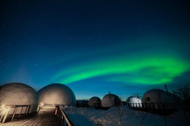 Kuzey Işıkları aynı zamanda Aurora, borealis ya da Igloo köyünün soğuk gecelerinde kutup ışıkları olarak da bilinir. Kış manzarasının büyülü doğasının güzel gece fotoğrafı.