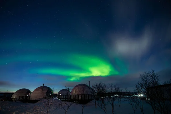 Northern Lights also known as aurora, borealis or polar lights at cold night over igloo village. Beautiful night photo of magic nature of winter landscape — стокове фото