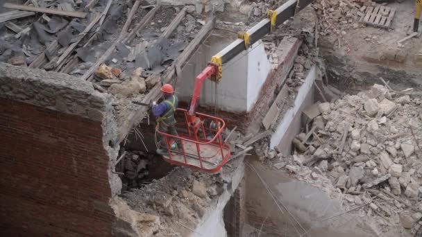 Sloop van oude verlaten huis, werkman in oranje helm op kraankorf vernietigen houten dak met kettingzaag. Deconstructie van het woonhuis. Urban Renewal 4k Hoge kwaliteit video — Stockvideo