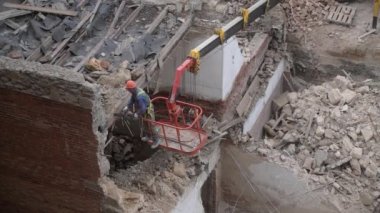 Eski terk edilmiş evin yıkılması, turuncu kasklı işçinin vinç sepetinde çalışması elektrikli testereyle ahşap çatıyı tahrip etmesi. Oturma odasının yeniden inşası. Kentsel Yenilenme 4k Yüksek kalite video
