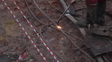 Metal kaynakçı binanın dışında çalışıyor. İnsan metalin parçalarını demirden kaynaklıyor. Parlak kıvılcımlar yavaş çekimde. 4k Yüksek kalite sinematik yavaş çekim, 120 fps