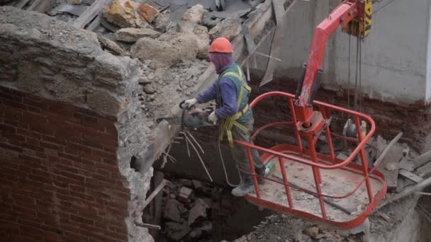 Demolição de casa abandonada velha, trabalhador em capacete laranja na cesta de guindaste destruir telhado de madeira com motosserra. Desconstrução da casa de estar. Renovação urbana 4k Vídeo de alta qualidade — Vídeo de Stock