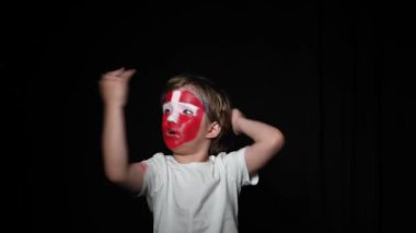 Happy taraftarı takımının zaferini kutluyor. Yüzü ulusal renklerle boyanmış genç bir adam. Mutlu bir adamın portresi milli takımını destekliyor.