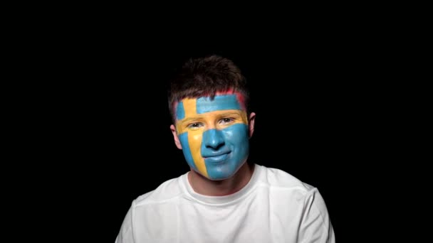 Happy fan celebrate victory of his team. Young man with face painted in national colours. Portrait of a happy man supports his national team at home — Stock Video