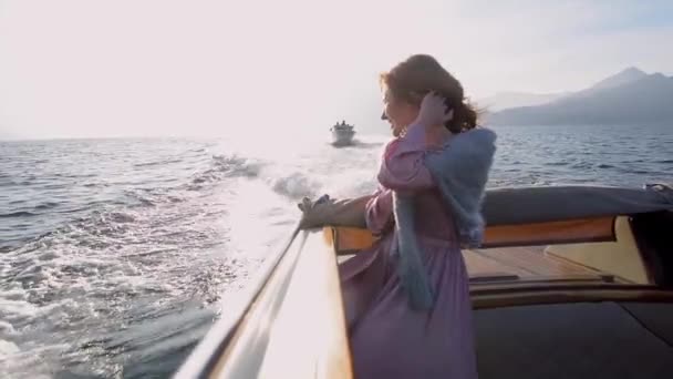 Piękna biała kobieta w luksusowej podróży łodzią motorową nad jeziorem Como na romantyczny miesiąc miodowy. Luksusowy ślub i pomysł na wakacje. 4k wysokiej jakości filmik slow motion — Wideo stockowe