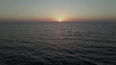 4K 'nin üzerinde kırmızı günbatımı. Güneş ufukta beliriyor. Kızıl gökyüzü, sarı güneş ve inanılmaz deniz. Yaz günbatımı deniz manzarası. Atlantik Okyanusu plaj günbatımı. Yüksek kalite 4k görüntü