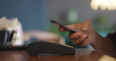Akıllı telefon kartı başvurusuyla NFC teknolojisiyle ödeme yapan adam.