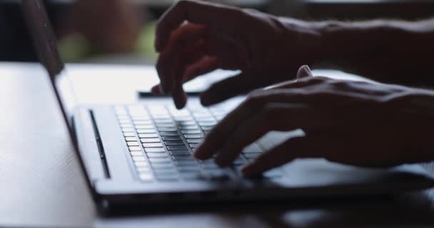 Mans manos escribiendo texto en el teclado del ordenador portátil en escritorio de madera.Guy utilizando la tecnología en línea para su trabajo. — Vídeo de stock