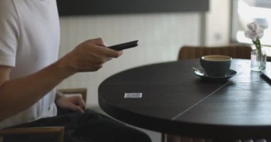 Erkek eli ekranda çalışan akıllı telefonun yakın plan görüntüsü. Restoranda ya da kafede QR kodunu tarayan adam. Müşteriler için çevrimiçi menü. Uygunluk, temassız konsept.