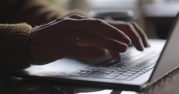 Mans manos escribiendo texto en el teclado del ordenador portátil en escritorio de madera.Guy utilizando la tecnología en línea para su trabajo. — Vídeos de Stock