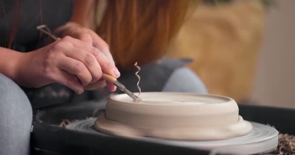 Kadın eli çömlek atölyesinde bir aletle nasıl bir iş yapılacağına bakar. Çamur talaşı. Yavaş çekim — Stok video