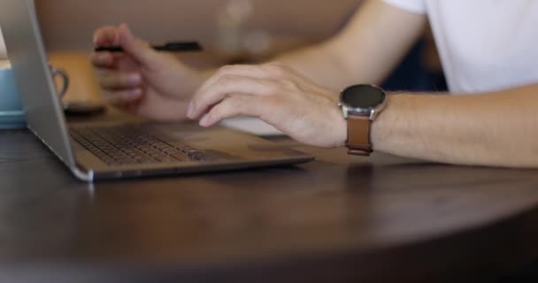 Επιχειρηματίας χέρια με ρολόι χρησιμοποιώντας touchpad στο laptop. Μαθητής πληκτρολογεί στο πληκτρολόγιο στο άνετο καφέ. Έννοια της απομακρυσμένης εργασίας. Αργή κίνηση — Αρχείο Βίντεο
