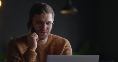 Gözlüklü adamlar karanlık arka planda cep telefonuyla konuşuyor. İş adamının iş yerinden ağır çekimde telefon görüşmesi yapması. Telefon eden iş adamının portresi.