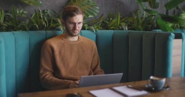 Uzaktan kumanda için bilgisayarı kullanan adam. Tabutta çalışan, gözlüklü, düşünceli, serbest çalışan bir iş adamı. Öğrenciler çevrimiçi çalışıyor