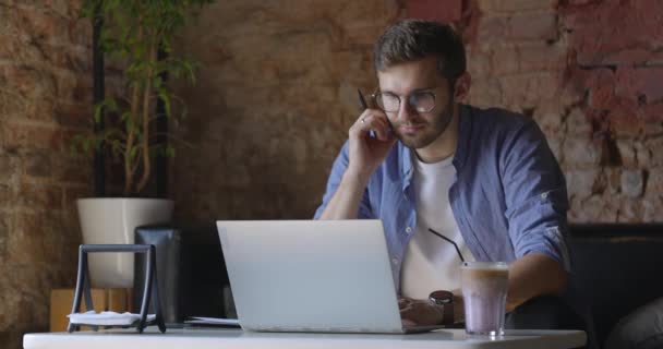 Mavi gömlekli, gözlüklü bir adam dizüstü bilgisayarına falan bakıyor. Eğitim ve işlerle ilgili kararlar. Derece çalışması kavramı — Stok video