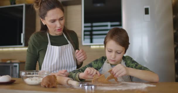 Glad mor och son matlagning kakor tillsammans i köket. Familjedag, matlagning, mamma och son koncept. Långsamma rörelser — Stockvideo