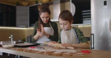 Mutlu anne ve oğul mutfakta kurabiye pişiriyor. Aile günü, aşçılık, anne oğul kavramı. Yavaş çekim