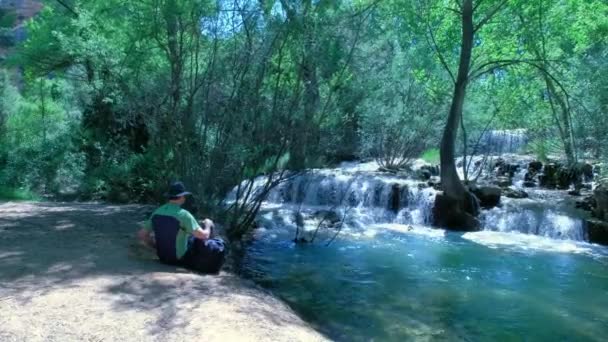 Чоловік Сидить Кидає Каміння Воду Природа Водоспадом Красивий Пейзаж Каскадом — стокове відео