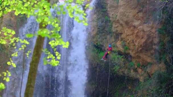 Скелелазіння Жінка Спускається Мотузкою Прекрасний Великий Водоспад Скелі Зелене Листя — стокове відео
