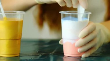 Bir sanatçı plastik bardakta akrilik renkleri karıştırıyor. Sıvı resim hazırlama. 