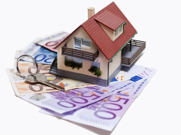 Casa con billetes en euros y llave de la casa Imagen De Stock