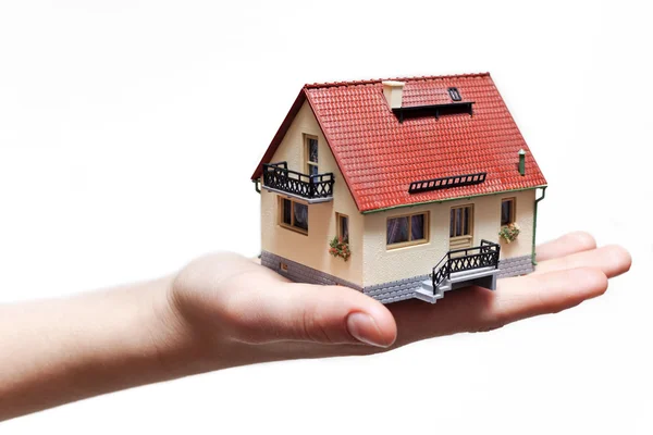 Mano sosteniendo pequeña casa en miniatura Imagen De Stock
