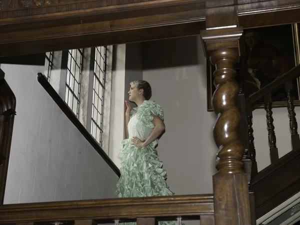 Mulher loira bonita em pé nas escadas com vestido de baile verde — Fotografia de Stock