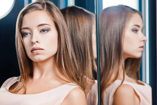 Beautiful woman reflected in a mirror — Stock Photo, Image