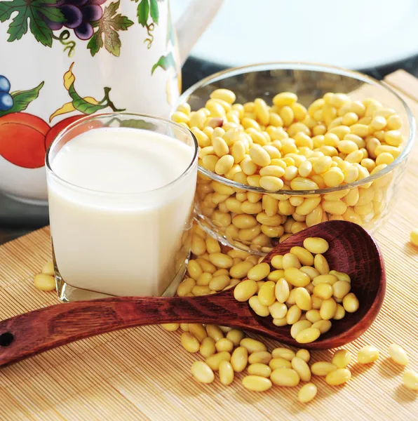 Latte di soia con sfondo di semi di soia — Foto Stock
