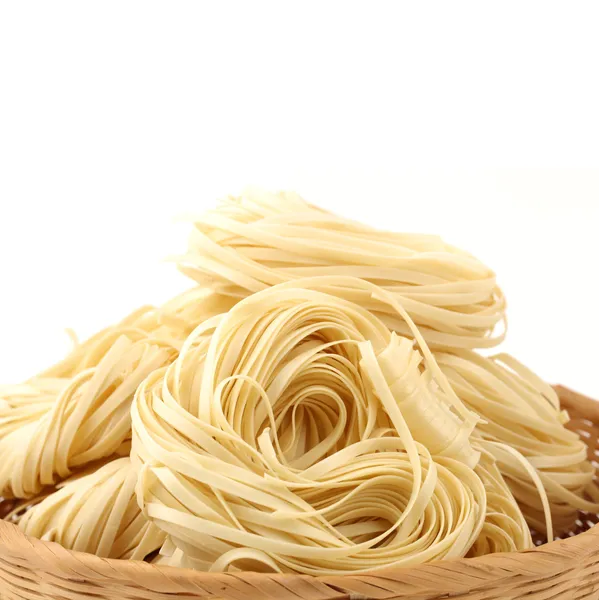 Italiaanse pasta tagliatelle nesten op witte achtergrond — Stockfoto