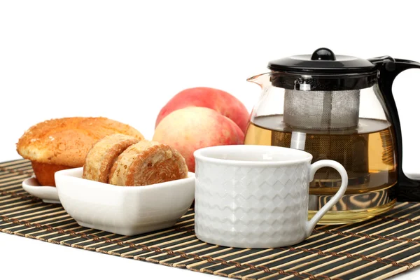 Pastel, taza y tetera de té sobre fondo blanco —  Fotos de Stock