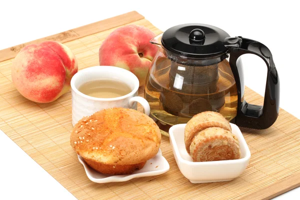 Pastel, taza y tetera de té sobre fondo blanco —  Fotos de Stock
