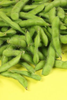 Fresh harvested soybean (edamame) plant isolated on yellow background clipart