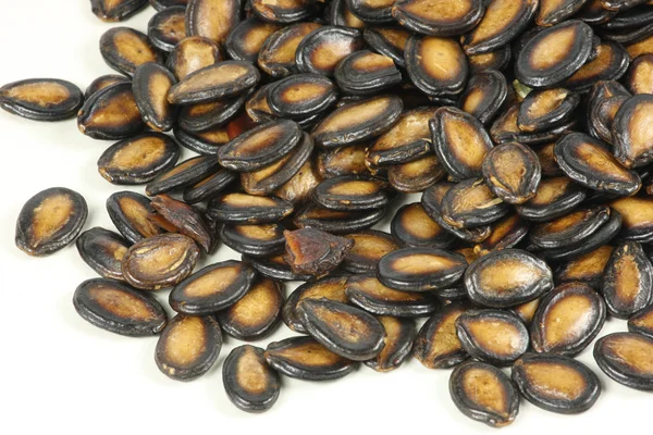 Beyaz arkaplanda siyah kavun tohumları — Stok fotoğraf