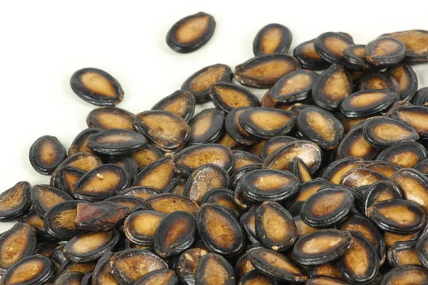 Beyaz arkaplanda siyah kavun tohumları — Stok fotoğraf