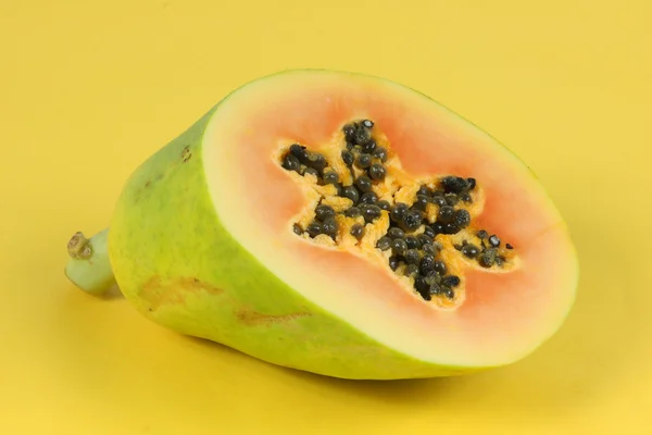 Papaya fruit sliced on half isolated on a yellow background. — Stock Photo, Image