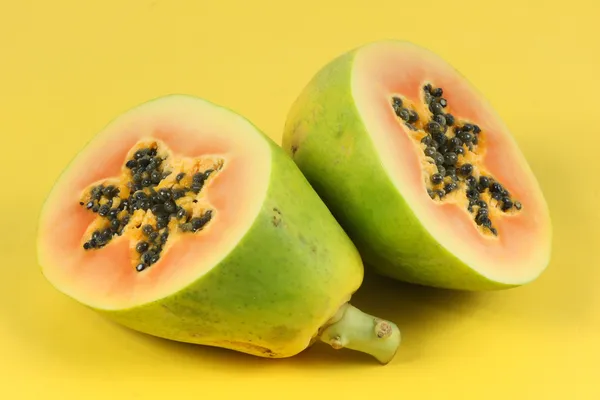 Papaya fruit sliced on half isolated on a yellow background. — Stock Photo, Image